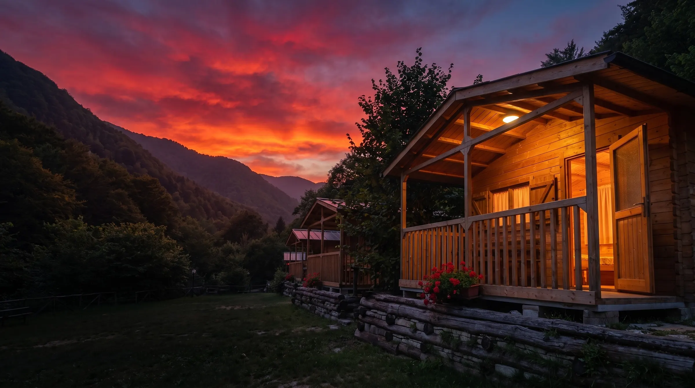 I bungalow in legno del campeggio al tramonto, con le montagne dell'Appennino sullo sfondo