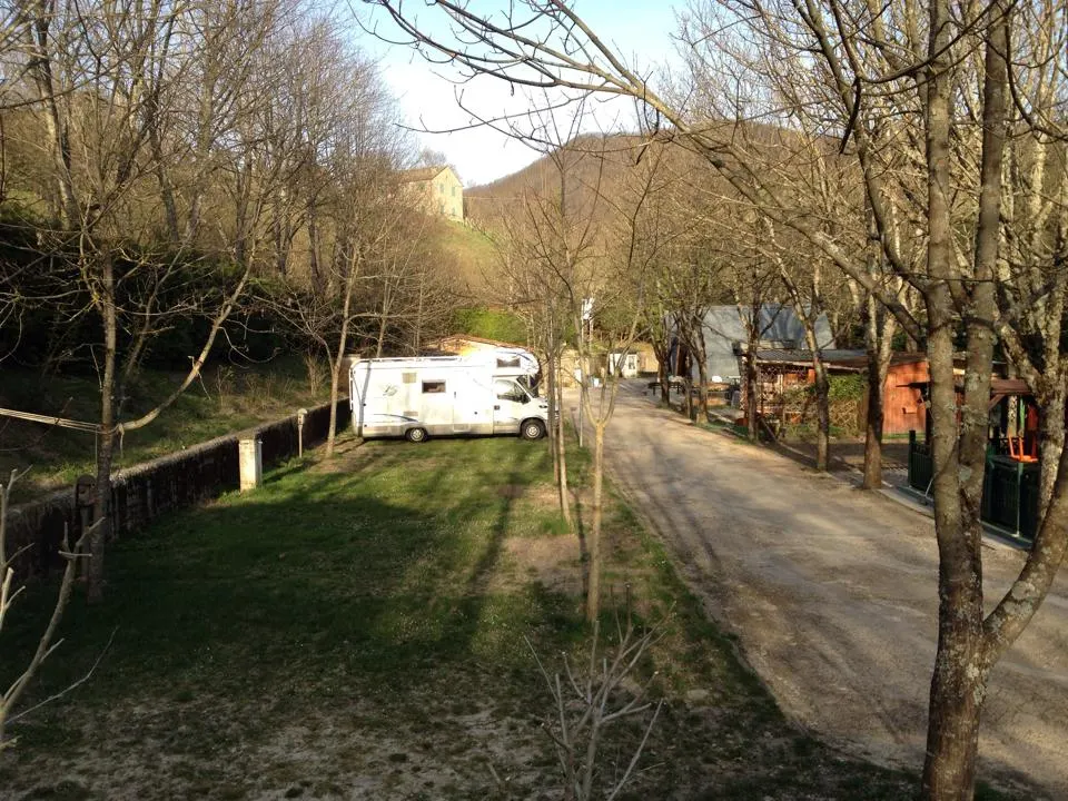 Piazzole del campeggio con un camper tra gli alberi